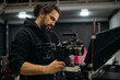 © Anna - The director of photography with a camera on the set. A professional videographer is working on filming a movie or commercial for a TV series. The filming process takes place indoors in a studio.
