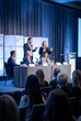 © you are doing great! - Professional business panel discussion with speakers and audience during a corporate conference in a modern venue with stage lighting and presentation setup