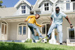 © Wavebreak Media - African American father and son kicking soccer ball on front yard wearing light-blue tee yellow top