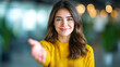 © Yuparet - Young woman in yellow sweater smiling and reaching out hand, showing dedication to service with warm holiday spirit, perfect for sales or customer support concepts
