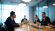 © Ataur400 - Blurred image of business professionals in a meeting around a table in a modern office setting