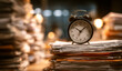 © AndiAzis - Vintage alarm clock resting on a stack of documents, indicating time management and deadlines, with soft focus background