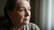 © photoplotnikov - Elderly woman reflecting by window with thoughtful expression in cozy home environment