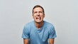 © photoplotnikov - Young male adult expressing frustration in casual blue t-shirt against neutral background
