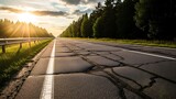 Cracked asphalt road stretches into the distance sun shining through trees travel and infrastructure concept