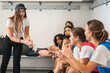 © Koldo_Studio - Women footballers in a changing room listening and clapping, receiving a motivational speech from their female coach before a game