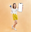 © sitthiphong - Cheerful Asian woman ready for vacation, holding passport with credit card and smartphone against pastel background.