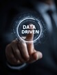 © Johannes - businessman touching a futuristic interface with the words data driven in the center symbolizing data analysis and decision making