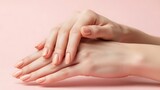 Elegant hands with natural nude manicure on a soft pink background showcasing beauty and feminine grace for nail art fashion and skincare design concepts