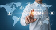© Pixel Studio - Man interacts with a digital SCM interface over a world map background showcasing supply chain management and global business connectivity with modern technology