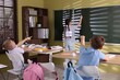 © New Africa - Girl with word Loser on her back getting bullying by classmates in classroom, selective focus