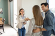 © fizkes - Confident female realtor congratulates young couple after successful home purchase, shaking hands, standing together in modern apartment. Property investment, new beginnings, closing real estate deal