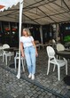 ©  Tsvyk L. - Fashionable woman wearing modern casual outfit and sunglasses, posing outdoors in city surroundings. Confident lifestyle look with minimalist style and natural light.