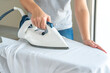 © Maria - Woman ironing white shirt on ironing board