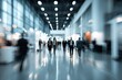 © farhan - People in a blurry, well-lit convention hall with modern architecture