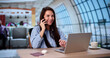 © Andrey Popov - Businesswoman Talking On Cellphone In Airport, Laptop Open On Table