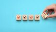 © Sutthiphong - Success building concept with hand stacking wooden blocks step by step, showing checkmarks and progress icons, representing achievement, planning, strategy, and long-term development.