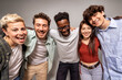© Lomb - Studio shot of cheerful diverse young adults standing in line and embracing each other with big smiles
