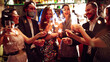 © maxbelchenko - A happy group is having fun at a bar, drinking drinks, and lighting sparklers in a cozy space. Young men and a woman are enjoying celebration and having fun at bar. Concept of party, celebration.