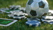 © Daria - Small soccer ball placed among poker chips on fresh green grass with blurred background and a digital device resting nearby on the field for an outdoor game setup