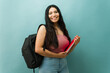 © AntonioDiaz - Latin young woman student posing with backpack and notebooks