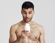 © Parkpoom - Astonished Discovery: A shirtless individual appears shocked, scrutinizing a medicine bottle closely, revealing an expression of surprise.