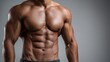© mila103 - Muscle definition is visible on the upper body of a person. The setting is a gym where physical activities take place. The focus is on the torso and strength.