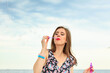 © Voyagerix - Woman blowing soap bubbles, having fun