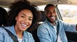 © Vasiliy - Happy young black couple smiling for a selfie in a car. Man and woman enjoying a road trip together