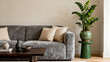 © Adobe Contributor - A cozy living room features a gray sofa with cushions, a wooden table, and a green potted plant in a stylish setting.