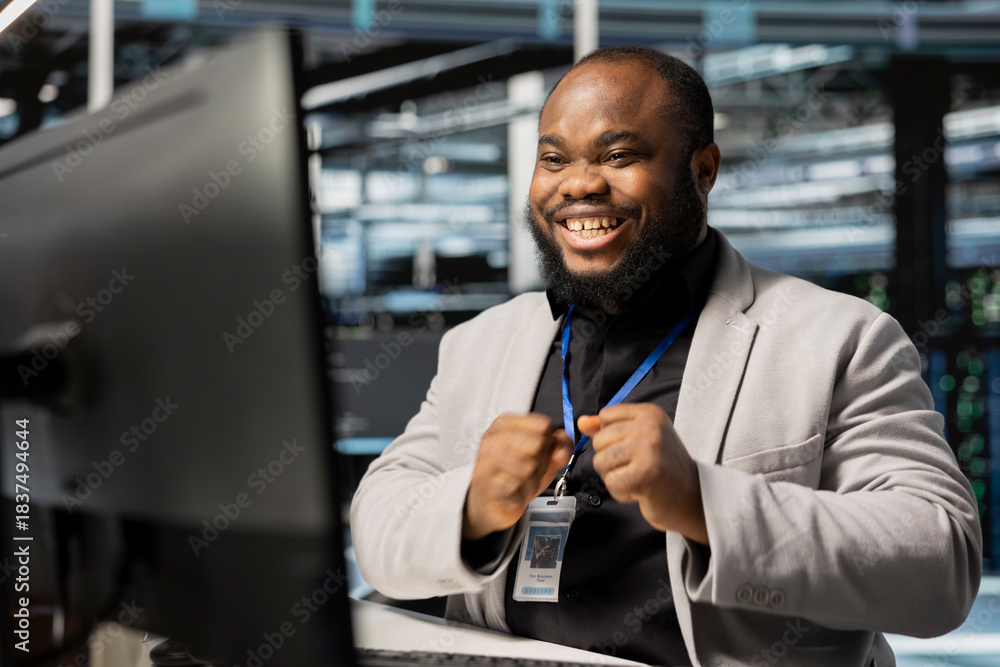 Smiling system administrator in data center checking infrastructure ...