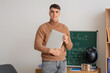 © Pixel-Shot - Male English teacher with laptop in classroom