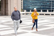 © Wavebreak Media - Diverse pedestrians walking across open plaza carrying coffee cup, smartphone and shoulder bags