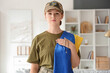 © Pixel-Shot - Young female soldier with flag of Ukraine and trident pendant at home