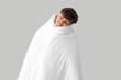 © Pixel-Shot - Handsome happy man wrapped in soft blanket sleeping on grey background