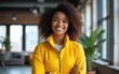 © wang - Portrait of a young confident black African American woman wearing a yellow jacket and standing in a modern open-space of a startup or tech company with space for text. High quality