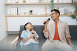 © itchaznong - Father and son enjoying karaoke, sharing laughter and joy
