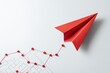 © Iftikhar alam - Red paper plane soaring above a strategy chart on a clean white surface, symbolizing innovative business planning and creative ideas in a competitive environment
