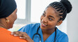 © abu - A compassionate Black nurse in blue scrubs offers support to her patient in an orange top. The scene is set in a bright room, symbolizing care and trust.
