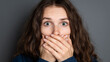 © Naufal - Young woman covering her mouth with a fearful expression. Emotional portrait showing shock, fear, anxiety, and surprise, suitable for concepts of reaction, crisis, or mental stress.