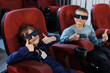 © Studio Peace - A girl and a boy wearing 3D glasses give a thumbs up while sitting in seats at the cinema.