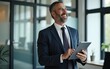 © li - Happy middle aged business man ceo wearing suit standing in office using digital tablet. Smiling mature businessman professional executive manager looking away. Generative AI. High quality