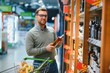 © Serhii - A man takes alcoholic drinks from the supermarket shelf. Shopping for alcohol in the store