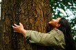 © Djavan Rodriguez - Woman embracing tree connecting with nature outdoors