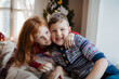 © Halfpoint - Small girl and boy in pajamas indoors at home at Christmas, playing.