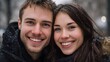 © Thares2020 - A happy young couple smiles warmly at each other in the falling snow during winter