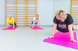 © danmorgan12 - Group of Mature Women at Bodyflex People Practicing Stretching Yoga Exercice Standing on Mats With Body Flex Bending in Room