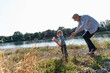 © TrueShot | Westend61 - Father and son playing together by the river in nature