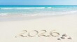 © barinovalena - The inscription '2026' on the beach sand against the backdrop of ocean waves, the concept of traveling in 2026