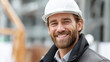 © Denis Yevtekhov - Faceless portrait of happy smiling confident construction worker, professional tradesperson, industrial site employee, positive attitude worker, safety equipment visible, defocused